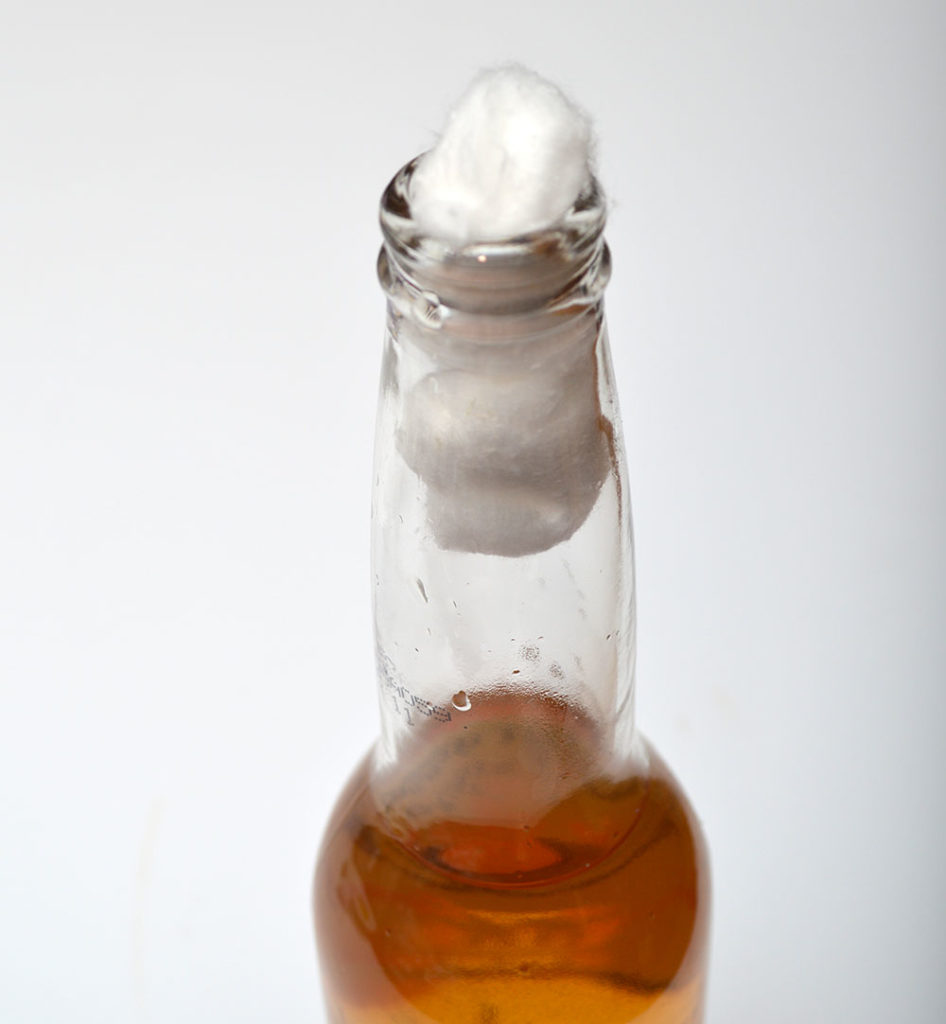 2. Fill the bottle to the neck.  3. Add cotton balls to neck and push down until the hit the surface of the vinegar and expand.