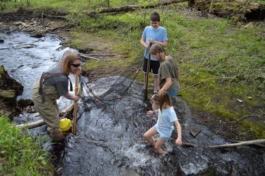 Jenny Kruckenberg teaches willing children the darter shuffle in the bone-chilling creek water, hoping to catch some brilliantly colored natives!