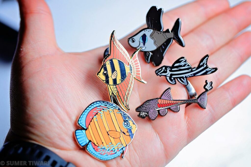 This handsome set of 5 enamel pins from Streamlined Sparkles showcases five iconic tropical freshwater aquarium species, and has arrived just in time for last-minute holiday gift-giving with a great conservation side-benefit.