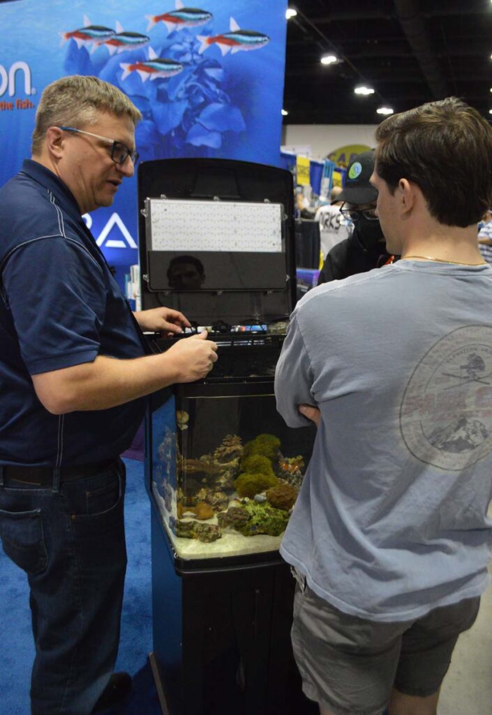 Aqueon's Andy Hudson walks expo attendees through one of Aqueon's all-in-one reef tanks on display at the show.