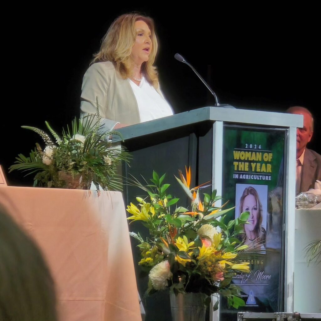 Segrest Farms President Sandy Moore, on stage at the Florida State Fairgrounds, receiving recognition as the 2024 Woman of the Year in Agriculture. Image credit: Roy Yanong.